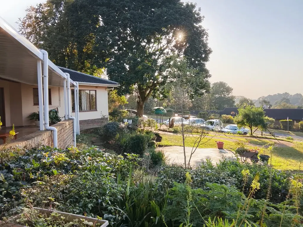 The Gillitts campus in early morning light, the school building among mature trees