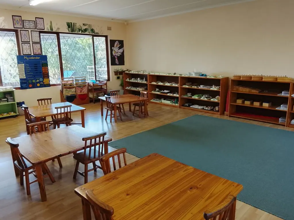A Montessori classroom with low shelves of practical life materials and a work rug