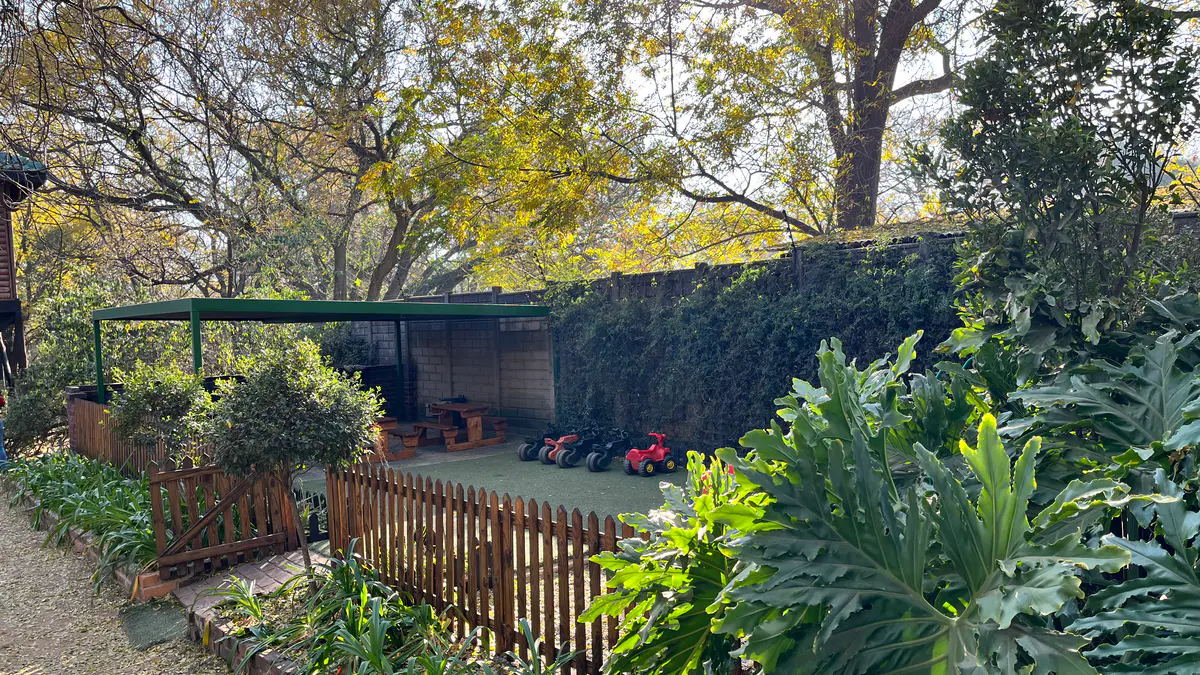A shaded structure beside a planted garden bed